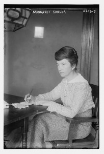Margaret Sanger, 1914, seated at a desk with pen and paper